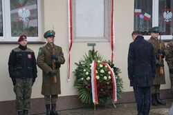 Prezydent Andrzej Duda złożył kwiaty przed tablicą upamiętniającą powstanie Szkoły Oficerskiej. Fot. Magdalena Ruczyńska (IPN)